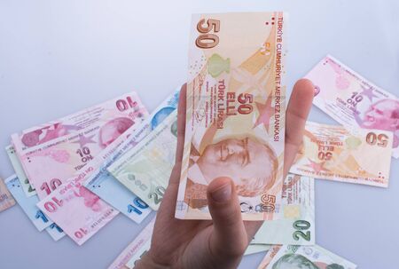 Hand holding Turksh Lira banknote  on white backgroundの写真素材
