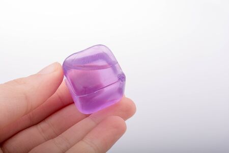 Hand holding fake colorful ice cube on a white backgroundの写真素材