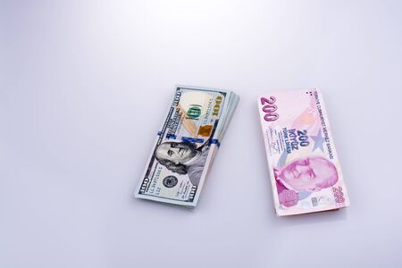 American dollar banknotes and Turksh Lira banknotes side by side on white backgroundの写真素材