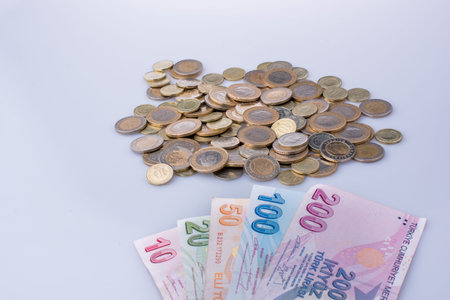 Turkish Lira coins and banknotes side by side on white background