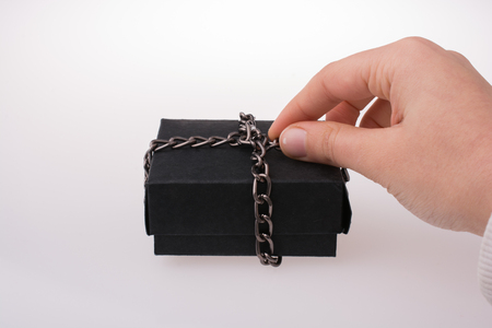 Hand holding a gift box of black color in handの写真素材