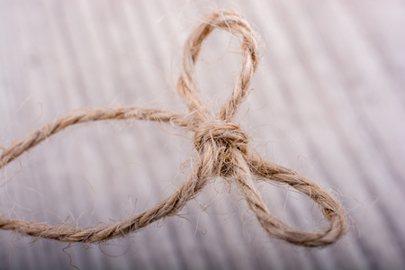 Thread tied  as knot on a light color backgroundの写真素材