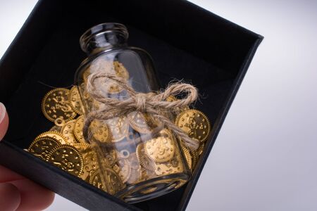 Fake gold coins and a bottle in a boxの写真素材