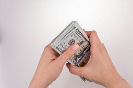 Human hand holding American dollar bill as money isolated on white