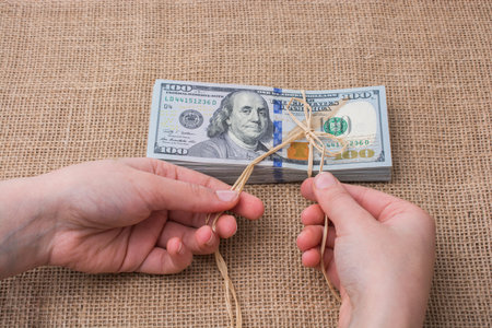 Banknote bundle of US dollar tied with colorful a ribbon