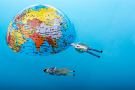 Little globe with    floating figurines around in water