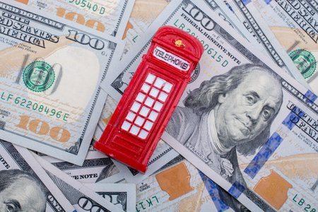 Model telephone booth is placed on spread US dollar Banknotesの写真素材
