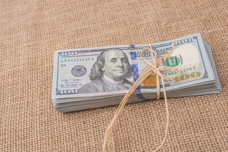 Banknote bundle of US dollar tied with colorful a ribbonの写真素材