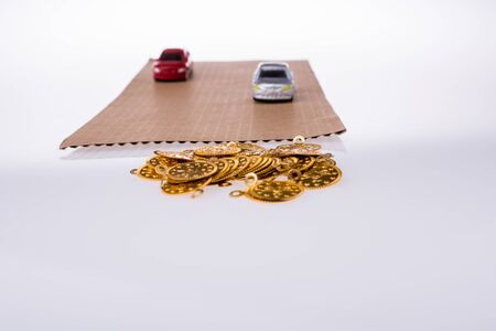 Colorful little toy cars and false coins on white backgroundの写真素材