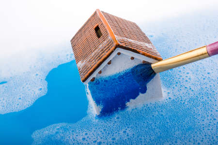 Little model house   and a painting brush in foamy waterの写真素材