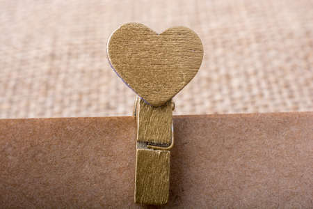 Colorful heart  attached to a clothespin in handの写真素材