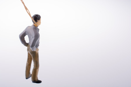 Man  figurine tied  with aa rope on a brown backgorundの写真素材