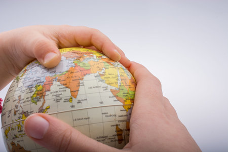 Child holding a globe in on a white background