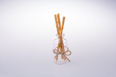 Little glass with crackers in hand on a white background