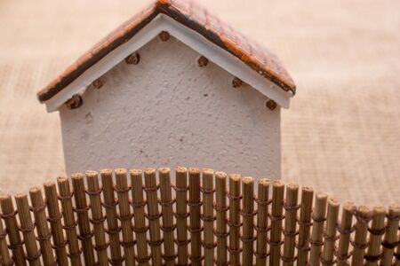 Little model house  found beyond a straw fenceの写真素材