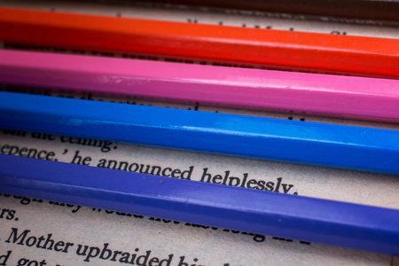Color pencils placed on the page of a book with text
