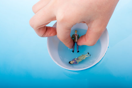 Little model globe with  figurines  floating in blue water