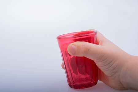 Drinking glasses of red color in hand  with patternsの写真素材