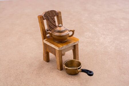 Little model pan and teapot on a model chairの写真素材