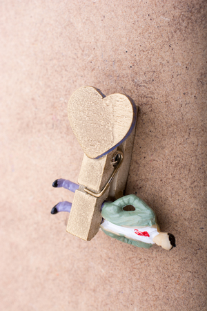 Man figurine trapped in a clothespin on groundの写真素材