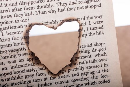 Heart shaped burnt out of a texted paperの写真素材