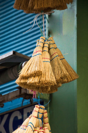 Set of yellow straw broom in a bazaar