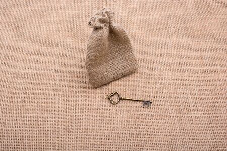 Retro styled golden color key beside a sackの写真素材