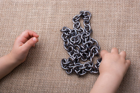 Chain made of metal in hand on canvas background