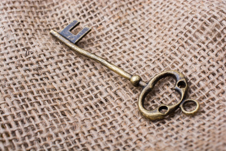 Retro styled golden color key on a linen canvas in view
