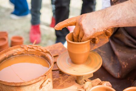 Potter`s hands shaping up the clay of the potの写真素材