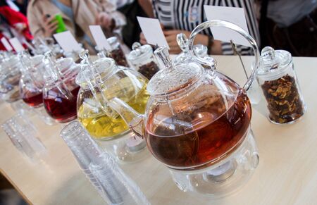 Herbal tea brewed in glass teapot and tea plant in a bottleの写真素材