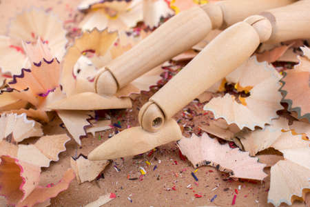 Man figurine standing amid colorful pencil shavingsの写真素材