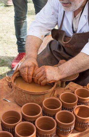 Potter`s hands shaping up the clay of the potの写真素材