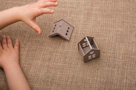 Child holding a model house on a linen canvasの写真素材