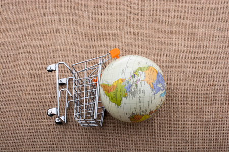 Globe with shopping trolley on thir sides on canvas