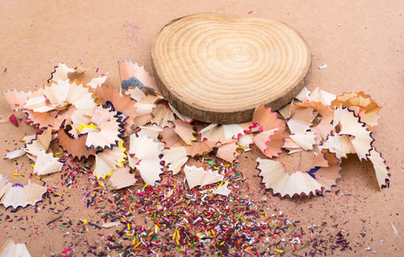 Colorful pencil shavings and a piece of woodの写真素材