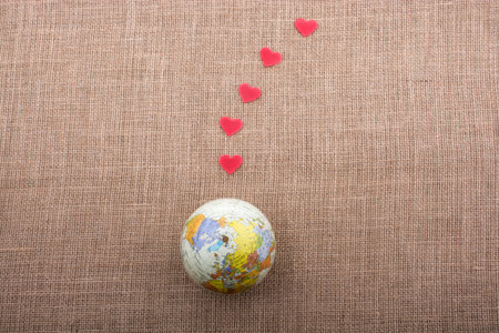 Hearts coming out of model globe on a canvas