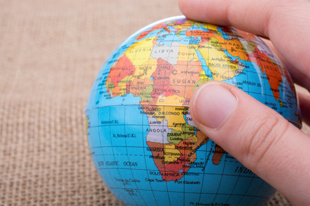 Globe in hand on a canvas backgroundの写真素材