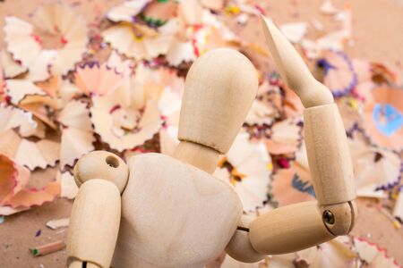 Man figurine standing amid colorful pencil shavingsの写真素材