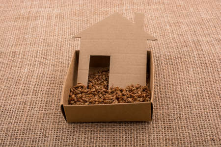 Little house shape cut out of paper on a canvas backgroundの写真素材