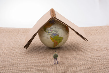 Figurine and globe with a notebook on the top of it