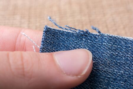 Denim canvas in hand placed on  linen canvas as  a backgroundの写真素材