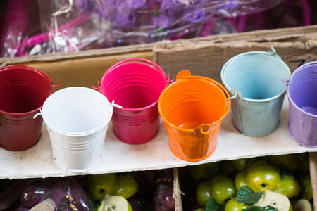 Little set of buckets of various colors in a market placeの写真素材