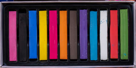 Crayons of various color in a box on a canvasの写真素材
