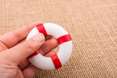 Life preserver in hand on canvas   canvas backgroundの写真素材