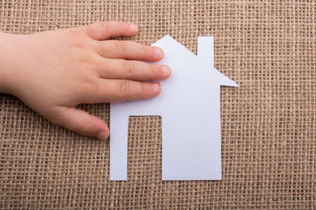 Hand holding a aper house on a canvas backgroundの写真素材