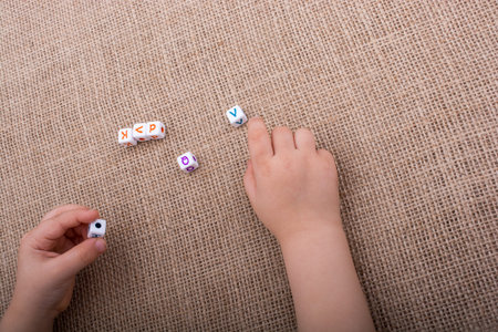 Colorful alphabet letter cubes in handon a  canvas backgroundの写真素材