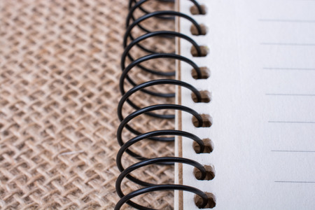 brown color spiral notebook placed on a canvas backgroundの写真素材