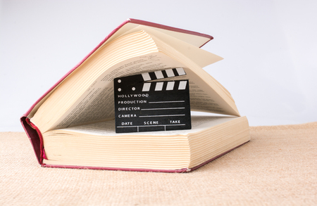 Movie clapper beside a book on a canvas backgroundのeditorial素材