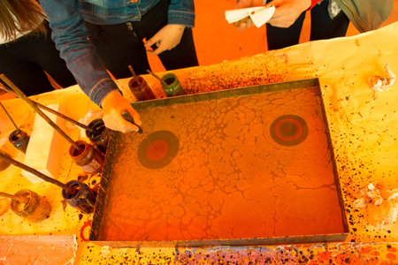 Hand drawing with stick stained inks on water surface